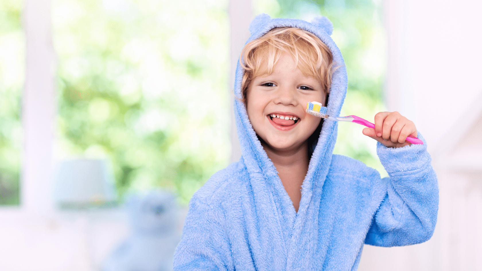 A young boy in a robe brushing his teeth